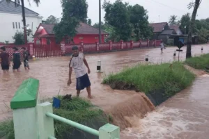 Warga melintasi jalan yang terendam banjir di Purworejo